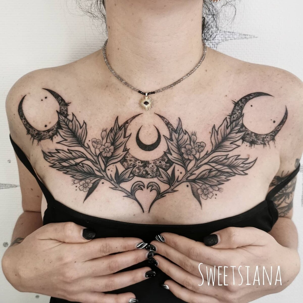 Tatouage blackwork de deux dagues ornées de fleurs