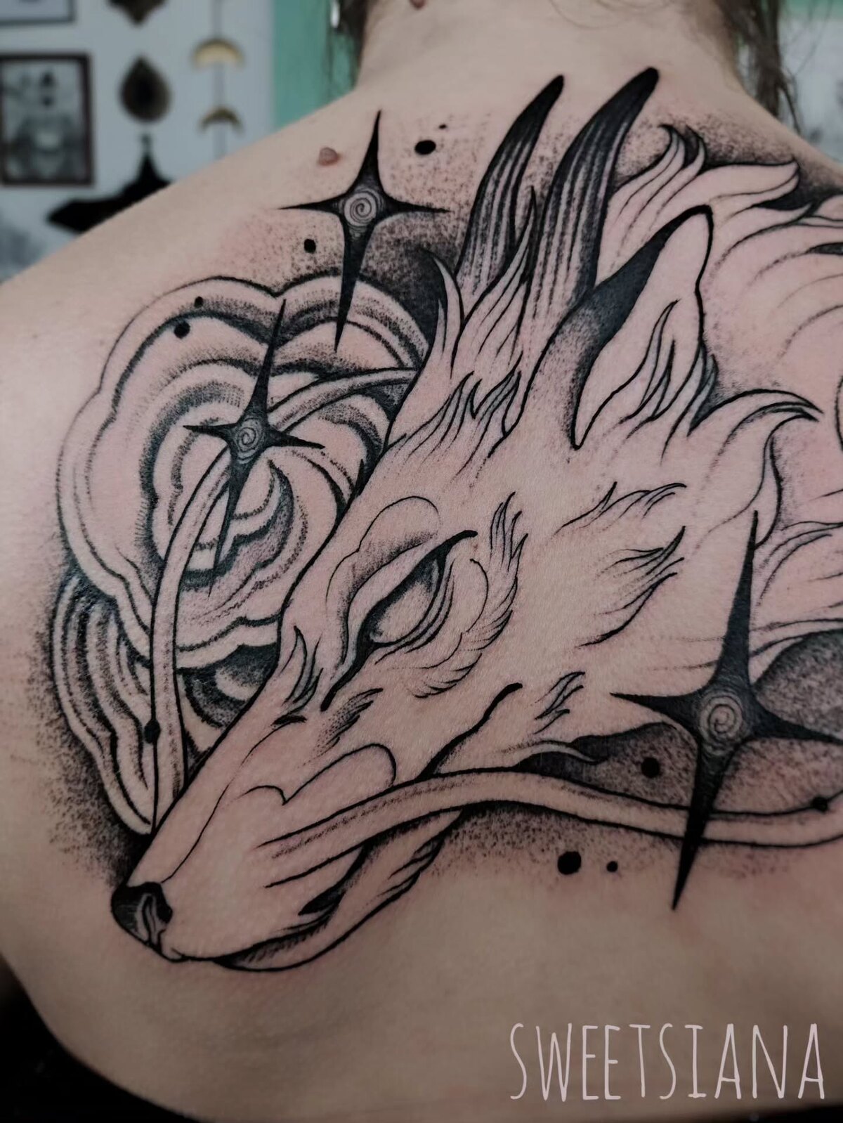 Tatouage blackwork d'une phalène sur le haut du dos